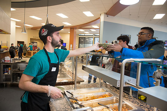 Student serving food in the dining center